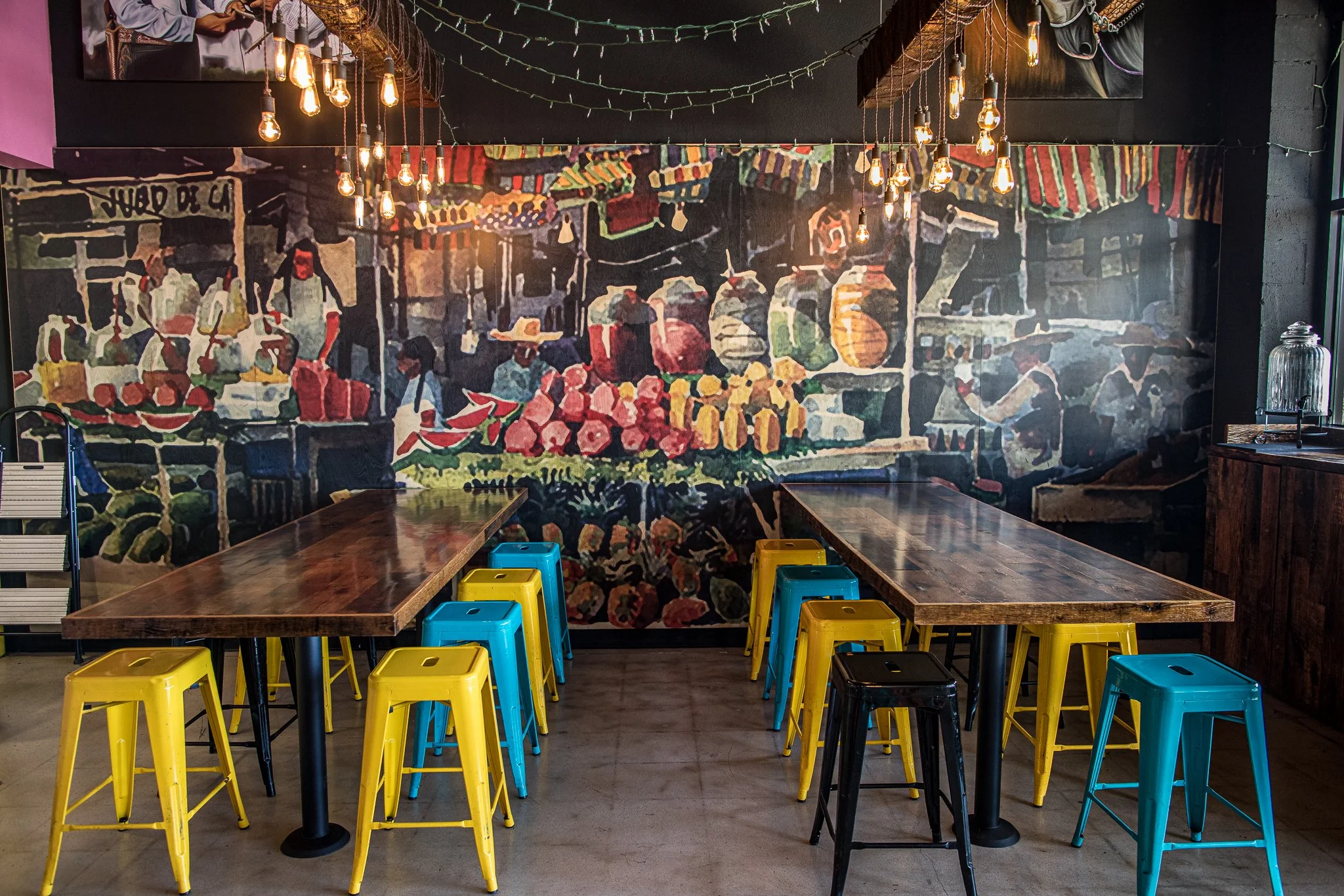 El Tianguis North Park location interior with colorful stools and market mural